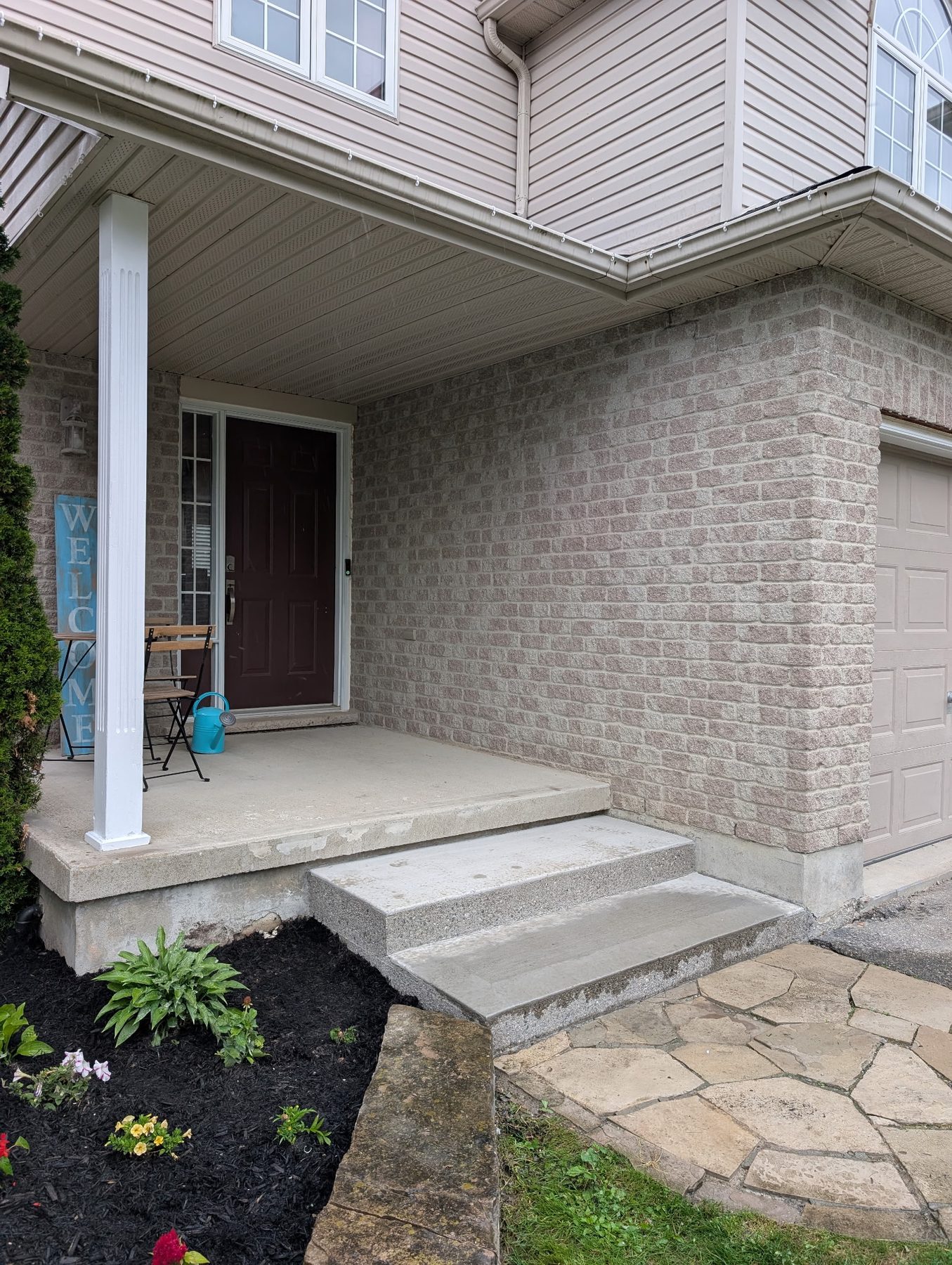 After: repaired step, fresh mulch and blooming garden bed